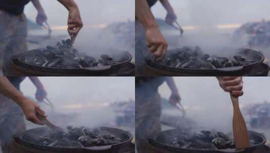 男人在户外用大铁锅煮扇贝高清在线视频素材下载