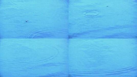 水滴落在一片蓝色的水面上高清在线视频素材下载