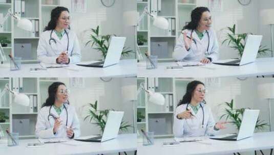 快乐的女医生在医院诊所使用笔记本电脑进行高清在线视频素材下载