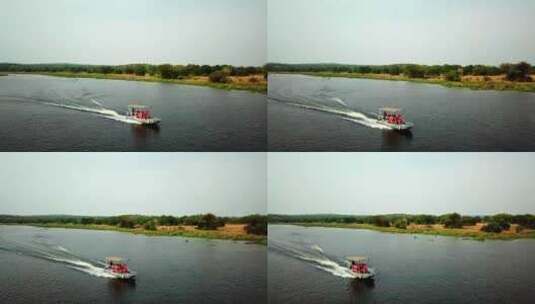 救生衣中的游客在湖中乘坐快艇，在非洲乘船旅行。-空中高清在线视频素材下载