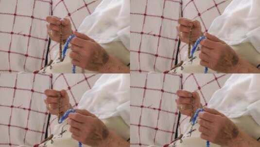 用念珠祈祷的老妇人的手高清在线视频素材下载
