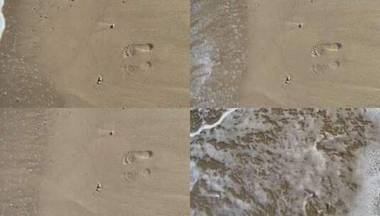 海浪冲走沙滩上的两个脚印高清在线视频素材下载