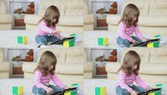 小女孩坐在地毯上玩平板电脑高清在线视频素材下载