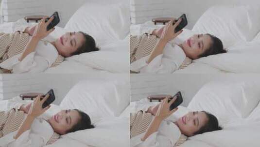 女青年家躺在床上用手机视频电话高清在线视频素材下载