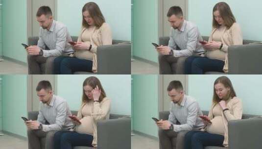 怀孕的夫妇坐在候诊室用手机发短信高清在线视频素材下载