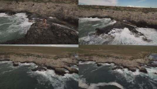 航拍女孩们在海边的岩石上拍照高清在线视频素材下载