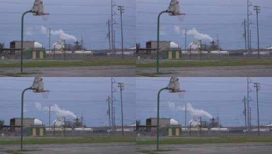 篮球场前工厂排放的烟雾高清在线视频素材下载