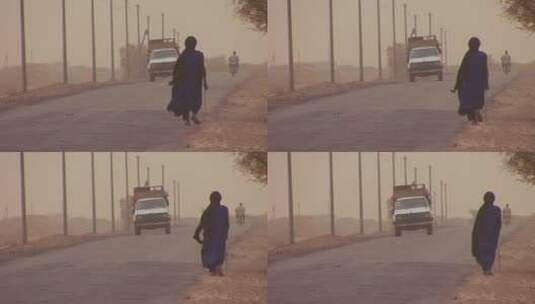 行人经过撒哈拉沙漠道路高清在线视频素材下载