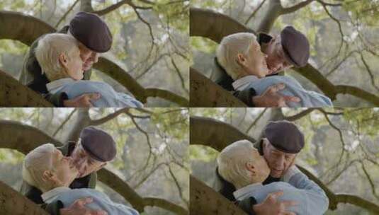 老年夫妇靠在公园树枝上接吻高清在线视频素材下载
