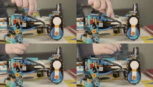 男孩把电池组装到机器人上。儿童机器人玩具高清在线视频素材下载