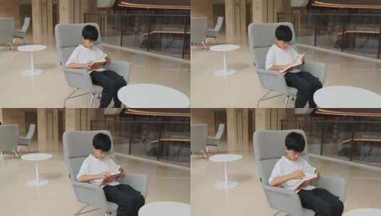 中国小男孩在图书馆大厅看书阅读高清在线视频素材下载