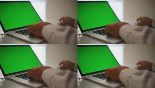 一名男子在一台绿色屏幕的笔记本电脑上工作高清在线视频素材下载