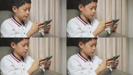 男孩在手机上玩游戏高清在线视频素材下载
