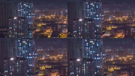 城市中夜间窗户照明变化的多层建筑。延时高清在线视频素材下载