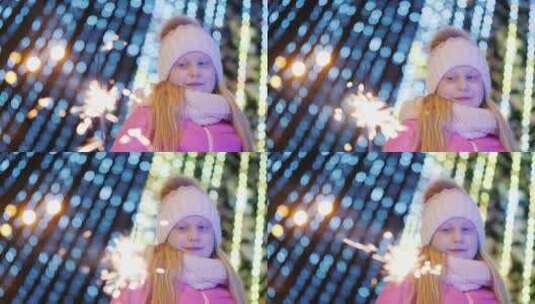 女孩在一棵大圣诞树模糊的灯光背景下玩火花高清在线视频素材下载