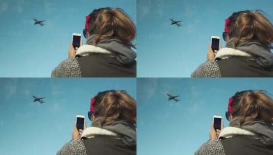 女人拿手机拍飞机飞过高清在线视频素材下载