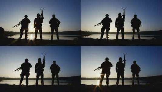 士兵的剪影在夕阳中举着枪摆姿势高清在线视频素材下载