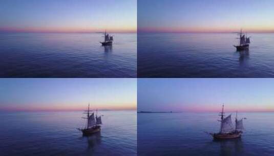 航拍日落时分海洋中的大帆船景观高清在线视频素材下载
