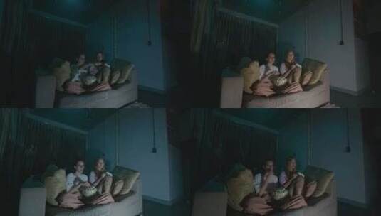 两个女孩坐在家里舒适的沙发上看电视高清在线视频素材下载