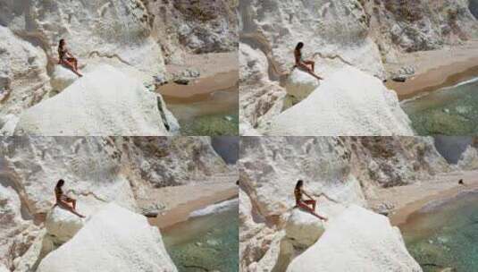 穿比基尼女性坐在海边岩石上高清在线视频素材下载