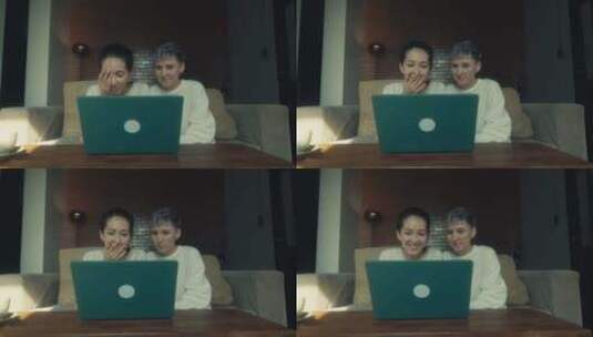 两个年轻女人在家一起放松时在笔记本电脑上看有趣的视频高清在线视频素材下载