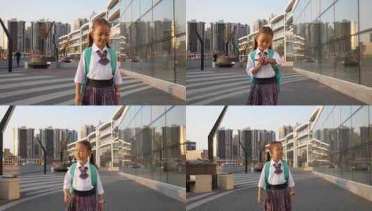 穿校服的小小学生在城市景观中上学高清在线视频素材下载