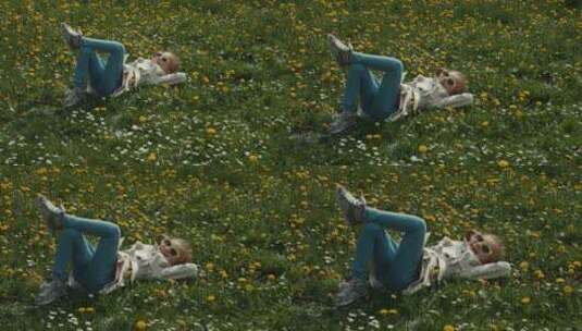 孩子躺在草地上在镜头前挥手高清在线视频素材下载
