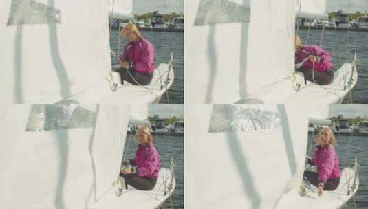 一个美丽的女孩在离开码头前在一艘白色帆船上拉绳子高清在线视频素材下载