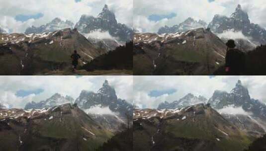 航拍旅行者站在山顶面向雪山高峰高清在线视频素材下载