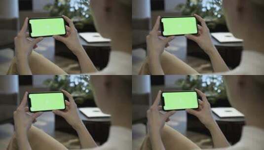 一名女子正在看绿屏手机高清在线视频素材下载