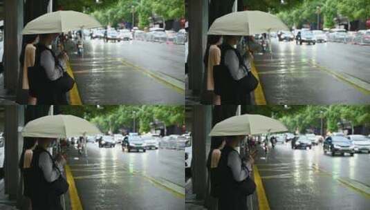雨天美女打伞玩手机等公交车高清在线视频素材下载