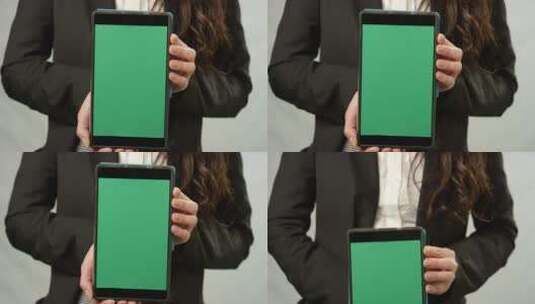 女子手持平板电脑在绿色屏幕前高清在线视频素材下载