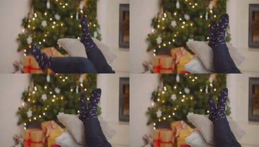 圣诞树前女人把脚放在靠垫上放松高清在线视频素材下载