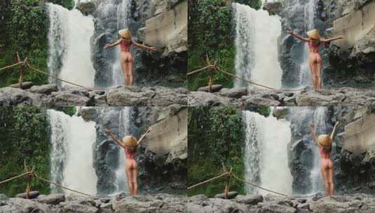 女孩在瀑布下伸出双手高清在线视频素材下载