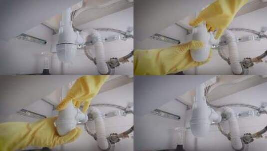 戴手套的水管工在水槽下收集虹吸管高清在线视频素材下载