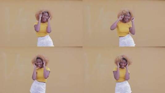 女子在黄墙前跳舞高清在线视频素材下载