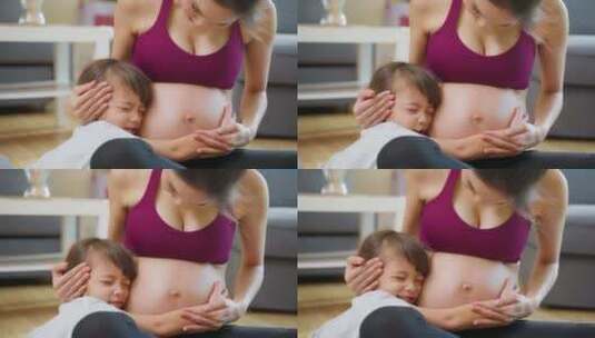 亚洲年轻可爱的女儿拥抱美丽的怀孕妈妈肚子。高清在线视频素材下载