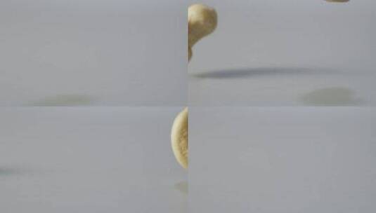 2K高速摄影两颗腰果掉落在白色背景下高清在线视频素材下载