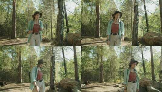 女人和狗徒步走在森林里高清在线视频素材下载