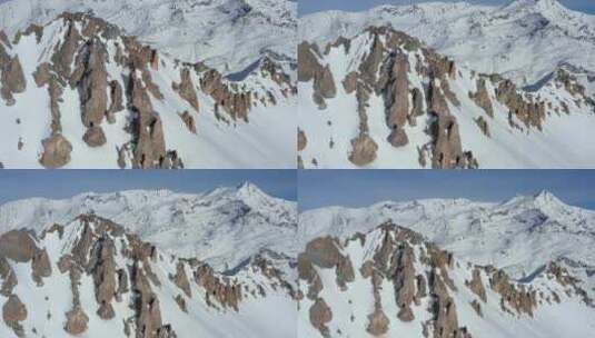 航拍被大雪覆盖的岩石山脉高清在线视频素材下载