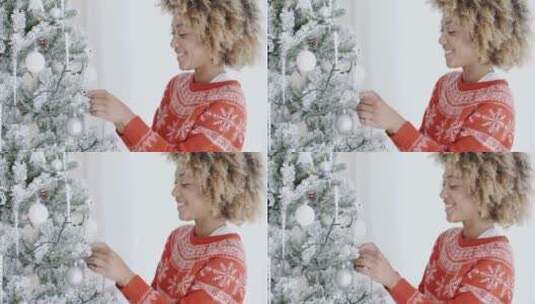 女孩在圣诞树上挂装饰品高清在线视频素材下载