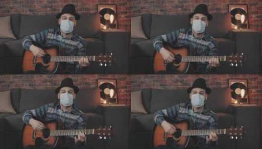 戴着医用面罩在家弹吉他的男人高清在线视频素材下载