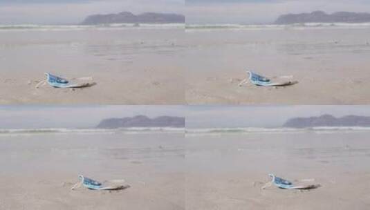 一个面罩躺在沙滩上的沙滩上，背景是波浪高清在线视频素材下载