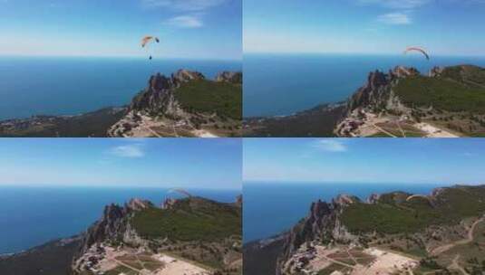 在美丽山峰的背景下，滑翔伞在滑翔伞上飞行高清在线视频素材下载