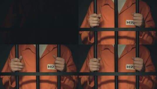 站在监狱铁栏后面的被监禁男子高清在线视频素材下载