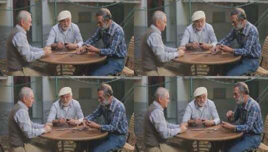 老人坐在院子里玩多米诺骨牌高清在线视频素材下载