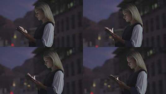 女人夜晚在街道上玩手机高清在线视频素材下载