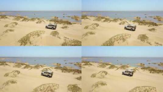 航拍在海岸行驶的吉普车高清在线视频素材下载