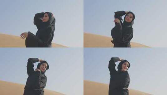 穆斯林女人在多风的沙漠中摆姿势高清在线视频素材下载