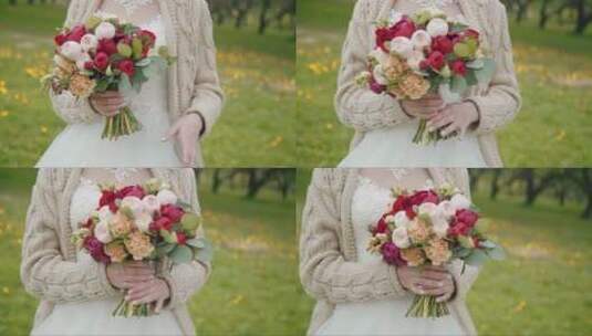穿着连衣裙和毛衣的新娘拿着一束牡丹和玫瑰高清在线视频素材下载